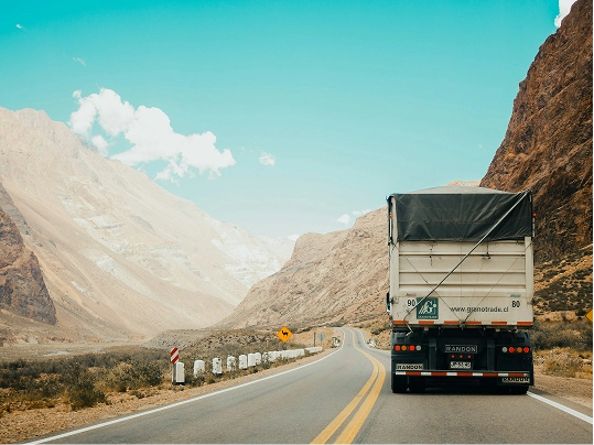 A covered truck driving along a mountain highway