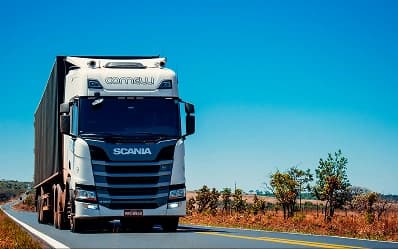 A white lorry driving along a sunny highway