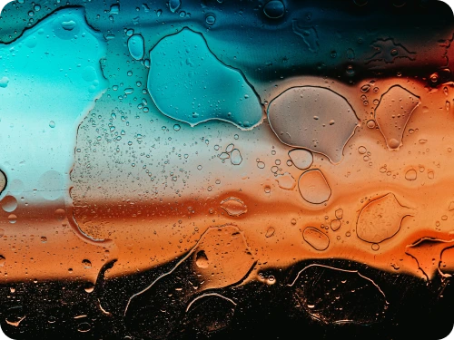 Water droplets on glass in teal and orange light
