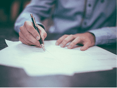 A person reading and signing a contract