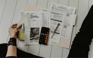 A calculator and insurance paperwork on a desk