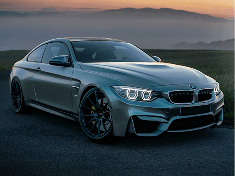 A grey BMW coupe parked at dusk