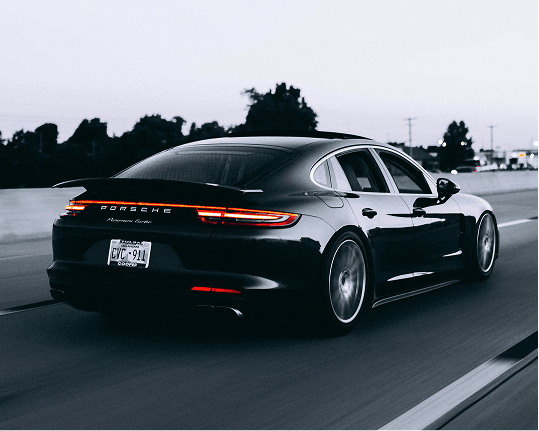 Black luxury sports car driving on highway representing Dealer Storefronts