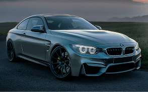 A grey BMW coupe parked at dusk