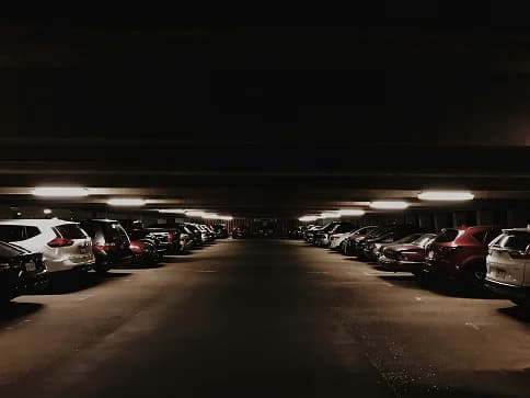 Rows of cars parked in a dimly lit indoor garage