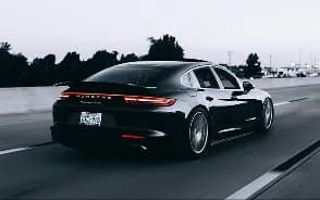 A black sports car driving on a road