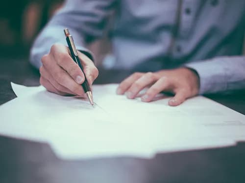 A person signing paperwork