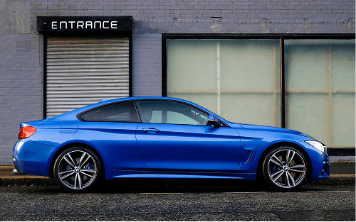 A blue car parked outside a building