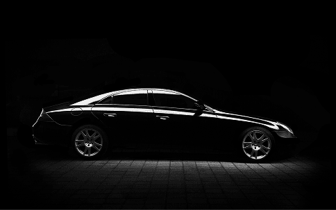 The silhouette of a black saloon car in low light