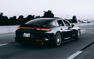 A black Porsche driving on a motorway